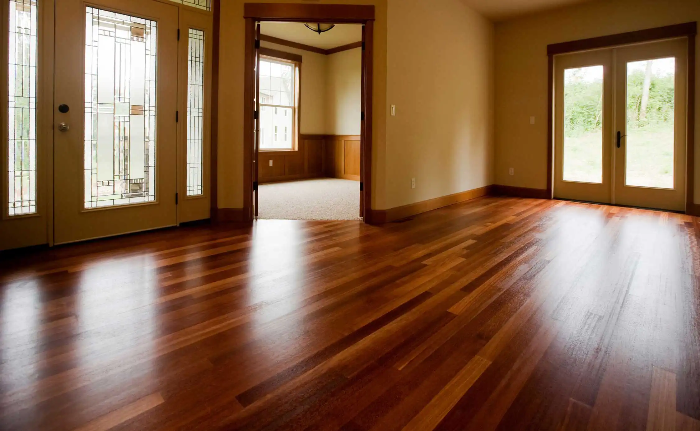 A glossy hardwood floor Andy finished, running through an entry hall toward french doors